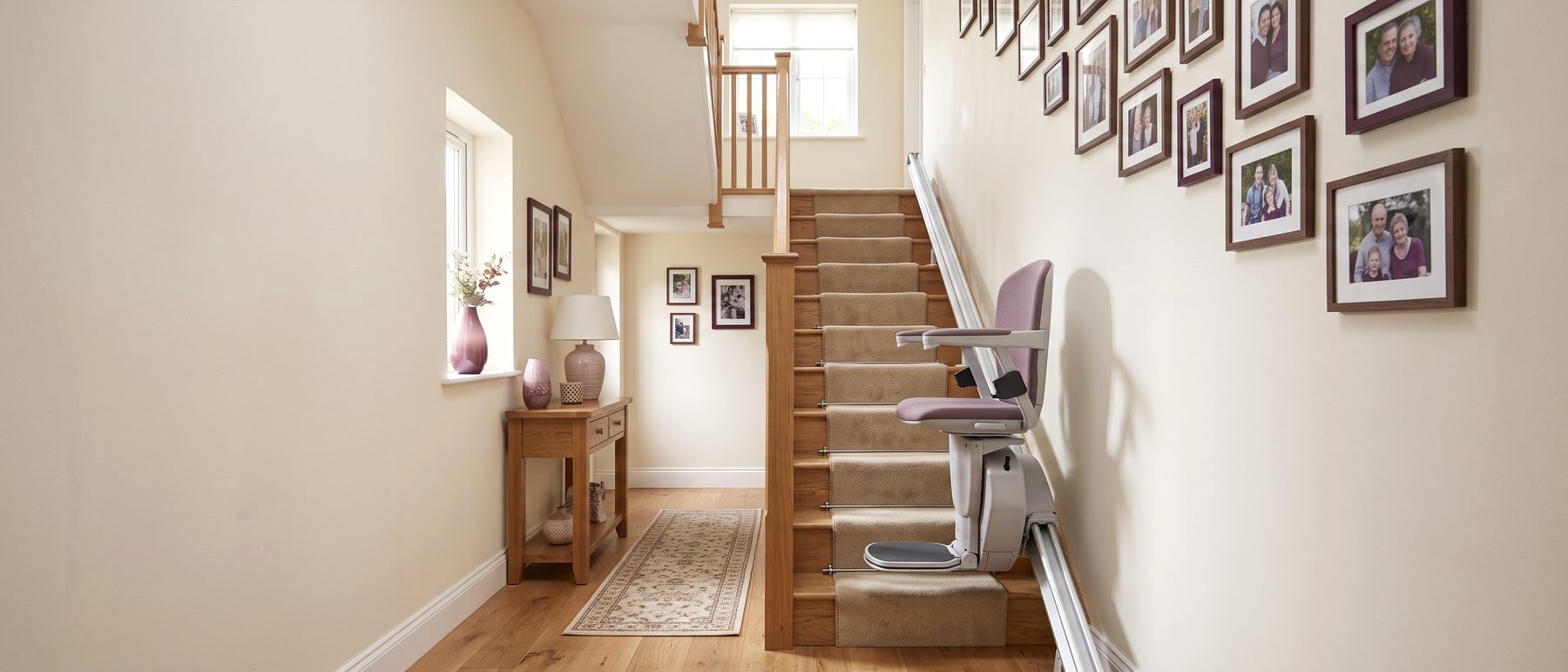 Stair elevator chair on a rail along a straight oak staircase in a family home